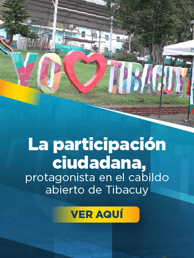 Banner muestra un aviso hecho en concreto que dice Yo amo a Tibacuy con un corazón y letras de colores sobre el césped