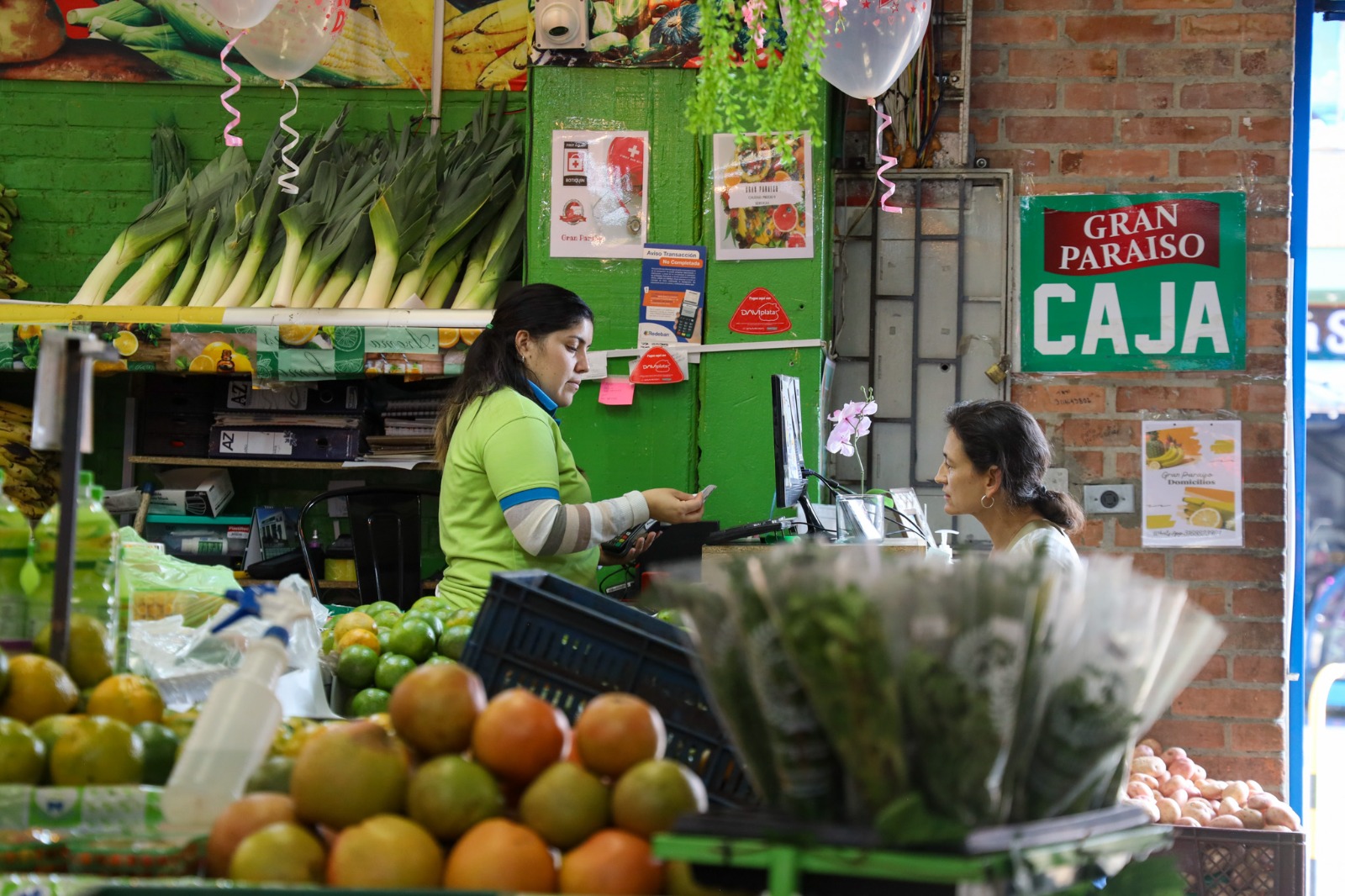 Fotografía de una plaza de mercado en la que se ve a una mujer trabajando