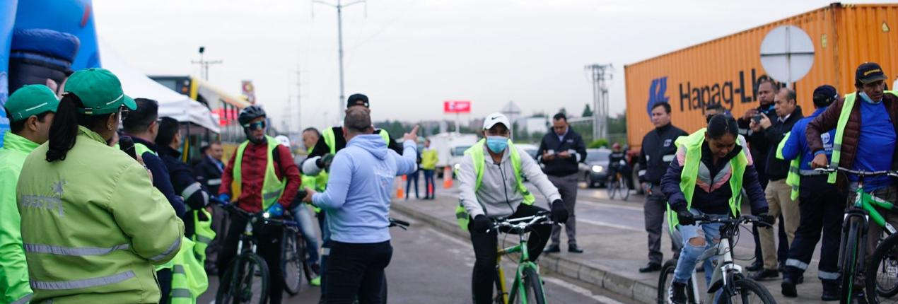 Fotografía muestra varias personas en el punto seguro regional, ubicado en la calle 80 en el kilómetro 1.5 Autopista Medellín. En la imagen sobresalen dos ciclistas que avanzan hacia sus lugares de destino