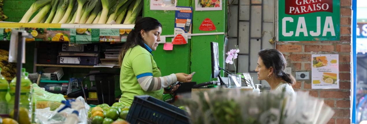 Fotografía de una plaza de mercado en la que se ve a una mujer trabajando