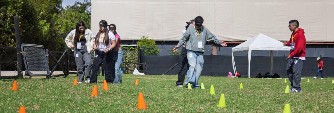 Fotografía muestra un espacio abierto en la que varios adolescentes compiten en un juego sobre el pasto