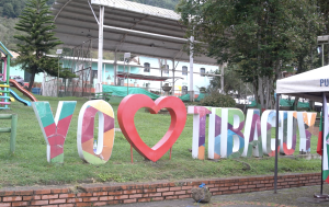 Fotografía de aviso que dice yo amo a Tibacuy, con un corazón incrustado y letras altas de colores sobre un césped