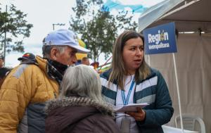 Fotografía de una funcionaria de la región metropolitana atendiendo a una ciudadana alrededor de una carpa instalada en la jornada de atención a la ciudadanía en el borde Bogotá - Soacha
