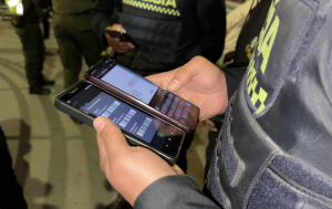 Fotografía que muestra dos teléfonos celulares en manos de un policía con el fin de ejemplificar el contenido de la noticia: Cada cinco horas una persona que compra elementos robados es capturada en Bogotá y municipios cercanos