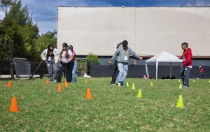 Fotografía muestra un espacio abierto en la que varios adolescentes compiten en un juego sobre el pasto