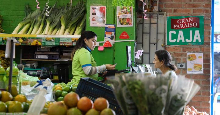 Fotografía de una plaza de mercado en la que se ve a una mujer trabajando