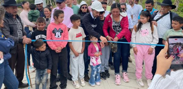 Fotografía tomada en Fusagasugá muestra la inauguración de una placa huella una vereda de Fusagasugá, en la imagen aparecen el director de la Región Metropolitana, el alcalde de municipio, niños y niñas, entre otras personas